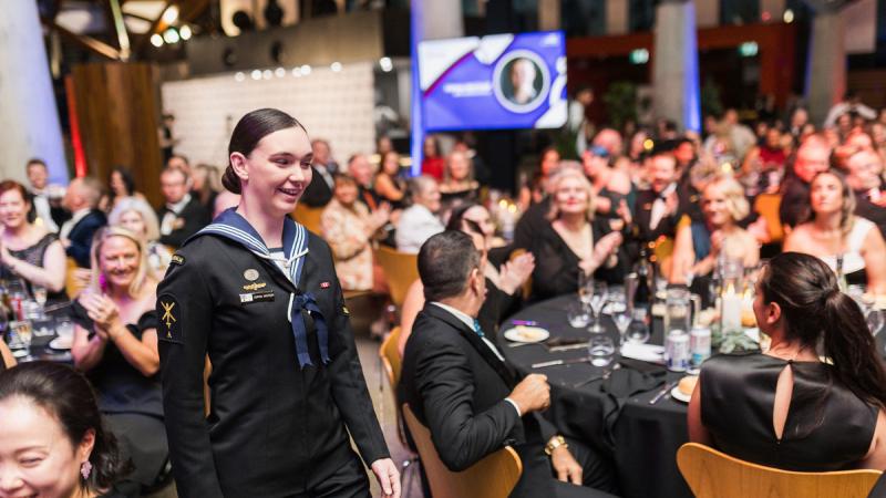 A woman walking through a cheering crowd.