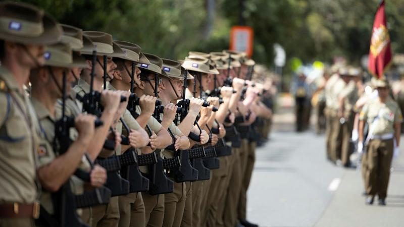 Soldiers are lined up and viewed from the side fading into the distance. 