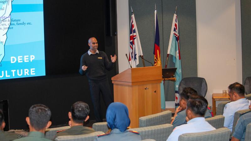 People sit in a lecture theatre listening to someone giving a presentation.
