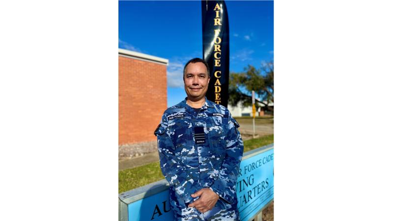 A man in military uniform outside a building.