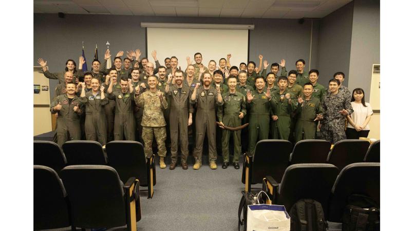 A group of military personnel put their arms in the air.