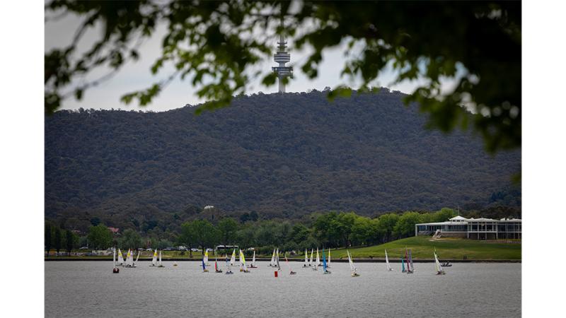 A collection of boats race on a lake.
