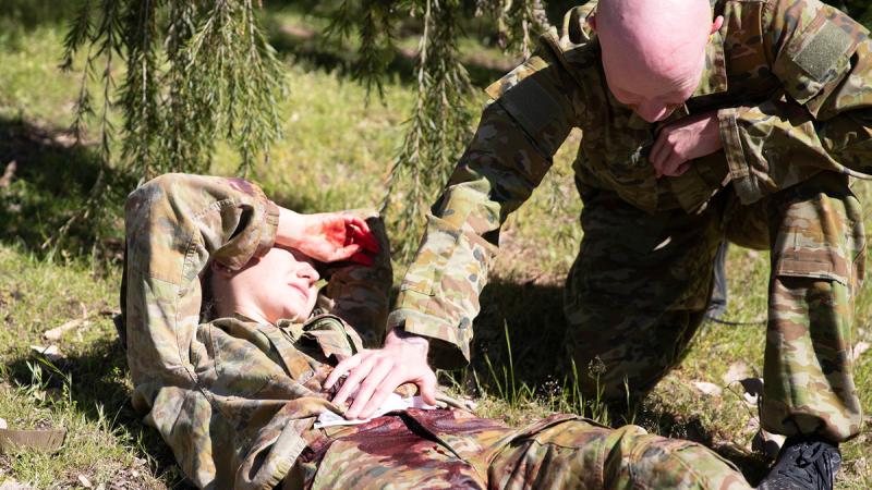 Uniformed ADF members simulate emergency treatment in a mass casualty event.