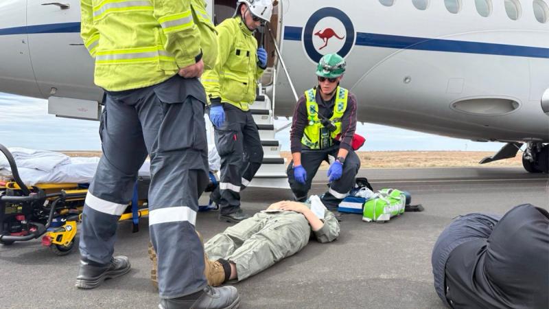 Civilian and Air Force personnel manage a simulated air crash emergency. 