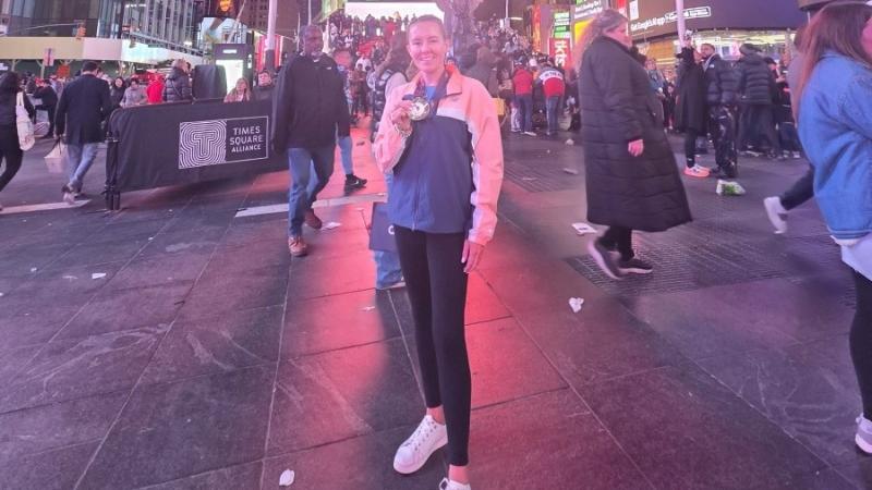 A Navy officer displays a New York Marathon medal after the race, in Times Square.