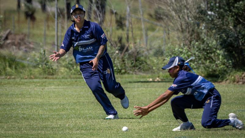 A Bavy cricket player runs in to back up a teammate fielding the ball.