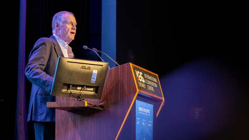 A man speaking at a lectern.