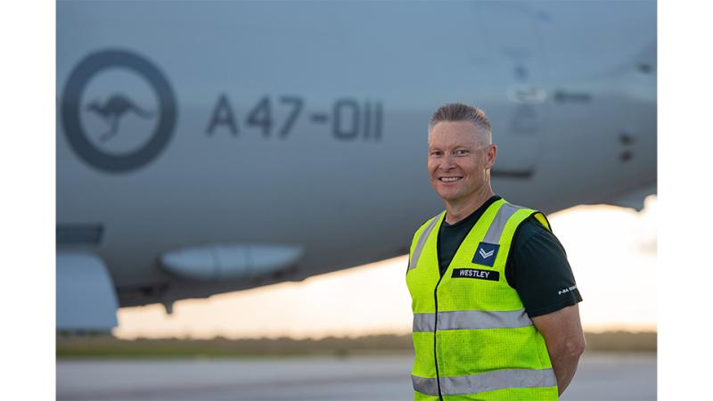 A man in hi-vis before an aircraft.