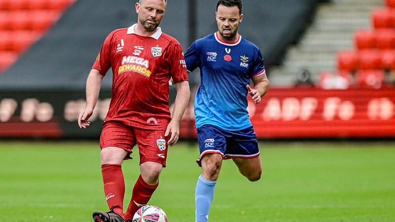 AB Benjamin Wright moves to intercept a pass in the game against the Adelaide United Legends.n ADF players moves to intercept an Adelaide United Legends player during a soccer game