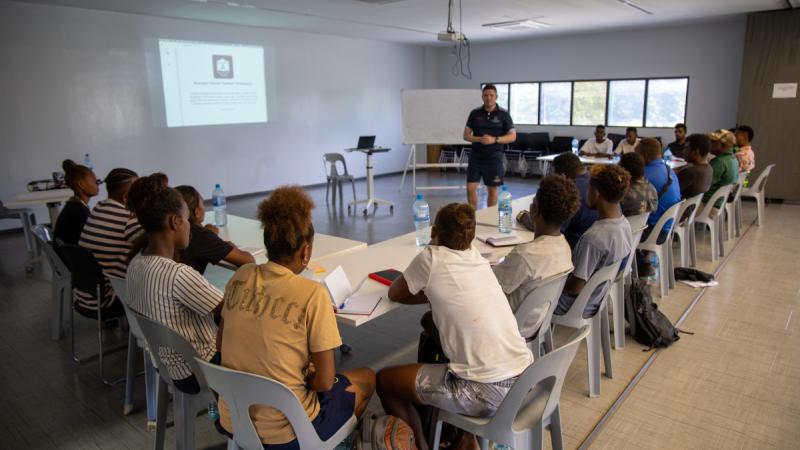 An instructor speaks to a classroom of students.