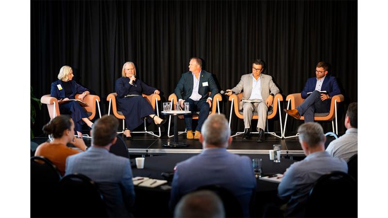 Five people speak on a panel for an audience.