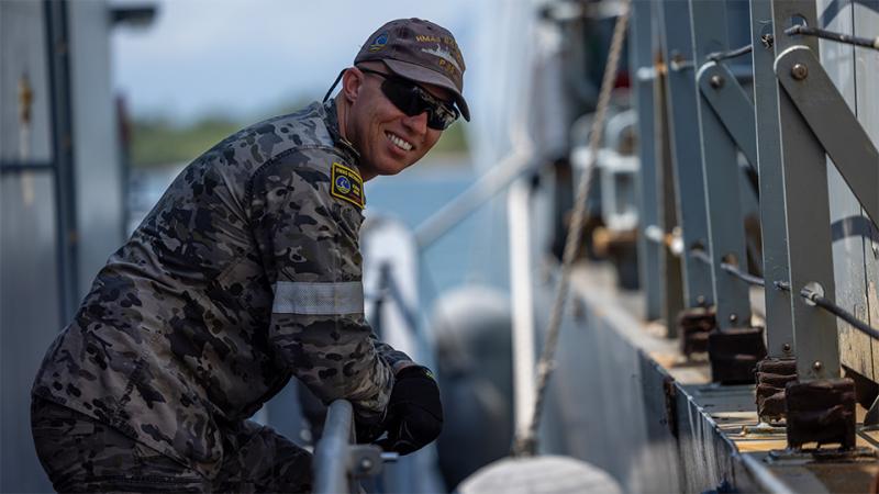A man in military uniform aboard a ship.