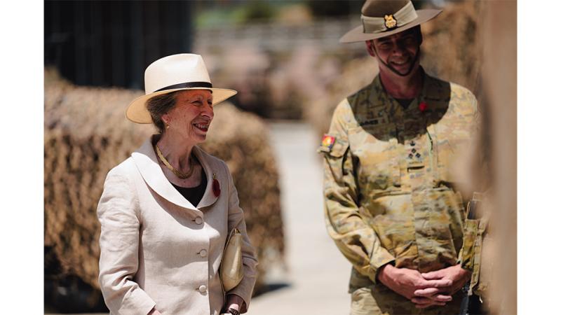 An elderly woman stands with a military man.