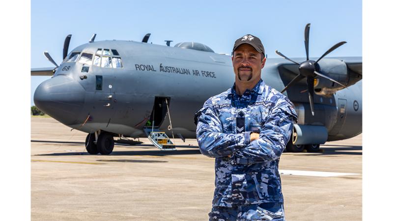 A man in military uniform stands before a Royal Australian Air Force aircraft.