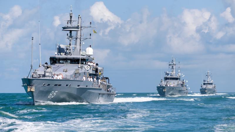 Three ships sailing in a row, one behind the other.