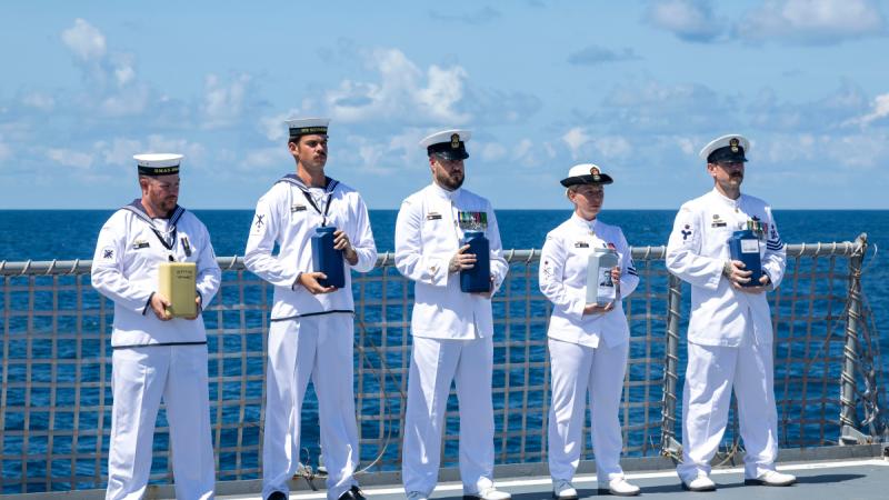 Members of HMAS Ballarat's ship's company prepare to scatter the ashes of four Royal Australia Navy sailors and one Royal Navy sailor during a Committal of Ashes to the Sea ceremony off the coast of Australia.