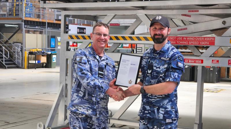 Sergeant Daniel Coccaro, from 37 Squadron, receives an Air Force Safety Award from Air Commodore Bradley Clarke.