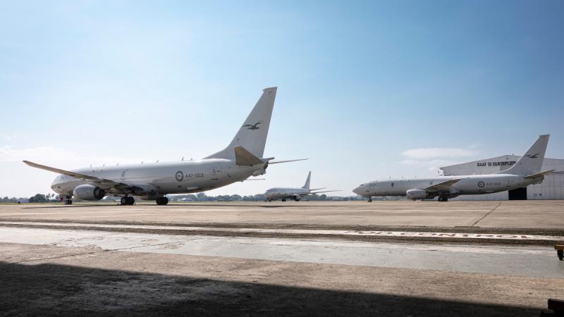 Three large aircraft on a tarmac with a hangar marked ‘RAAF’ in the background.