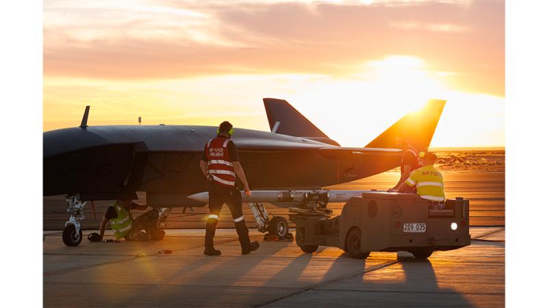 Air Force personnel with an air craft at sunset.