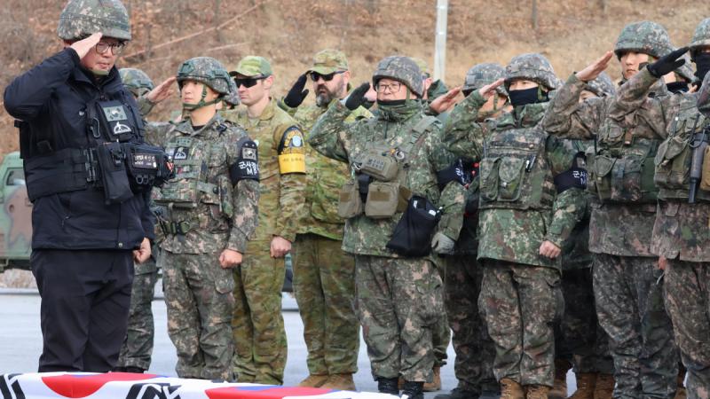 Australian and Korean personnel salute remains exhumed from the Korean DMZ.
