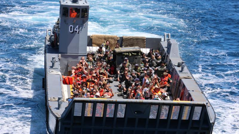 Children from Lord Howe Island Central School and their guardians are welcomed on board HMAS Canberra via landing craft for a tour of the ship. 