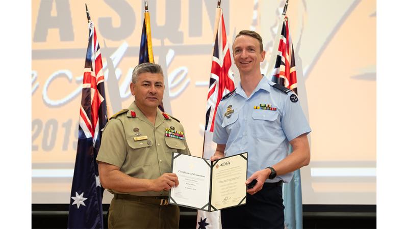 Two military men showcase an award.