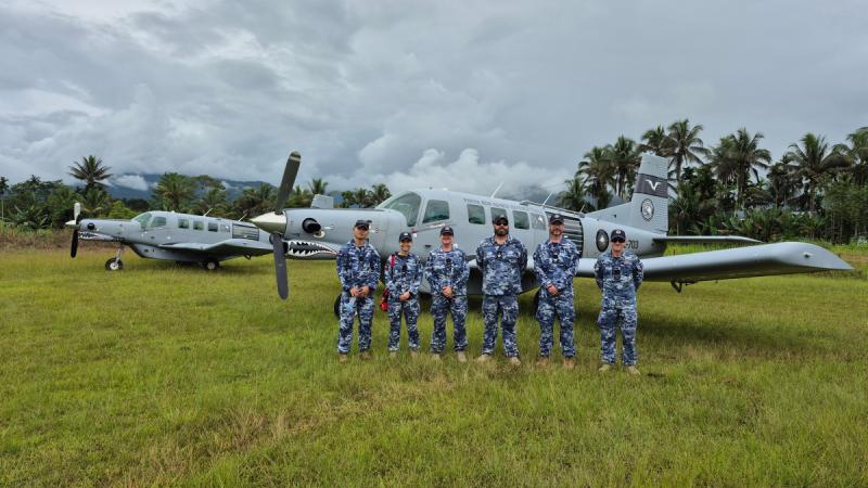 Air Force personnel line up with Papua New Guinea Defence Force aircraft in the PNG highlands.