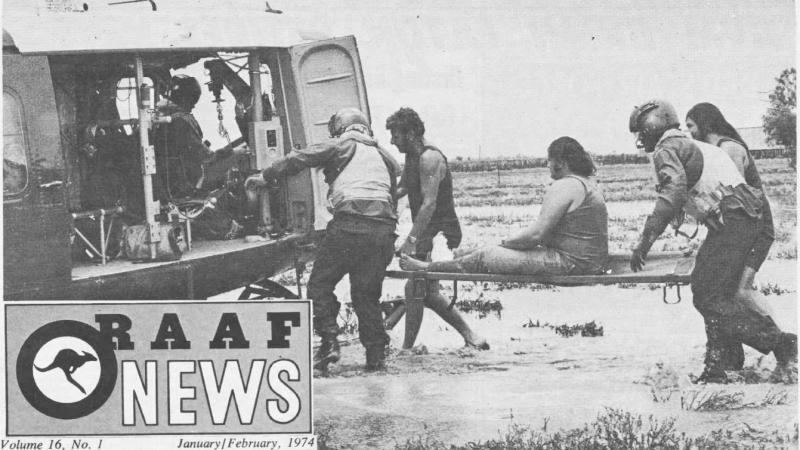 A snippet of a RAAF Newspaper clipping picturing people helping a man on a stretcher in shin-high water.