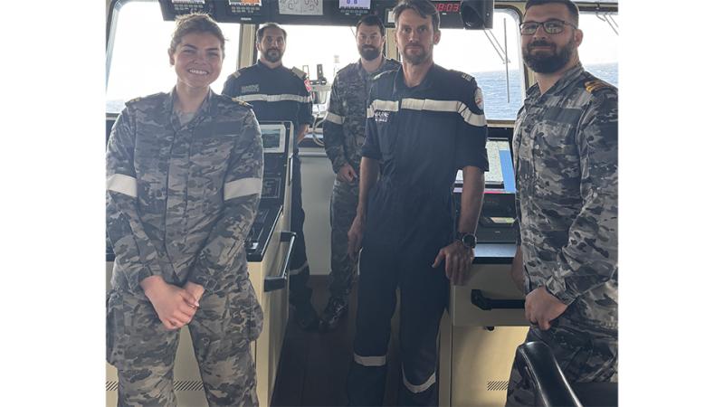 Five military personnel inside a boat.