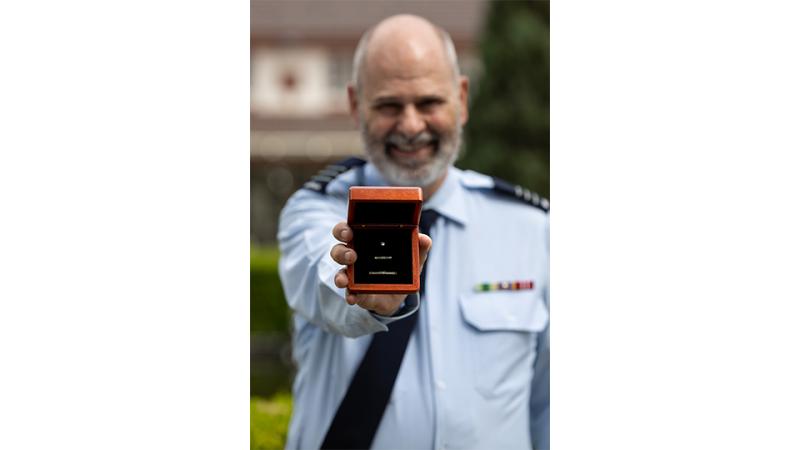 A military member presents a medal.