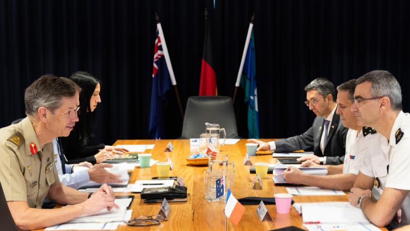 Six people sit at a meeting table.