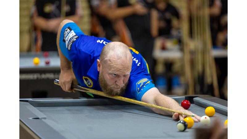 A man plays pool.