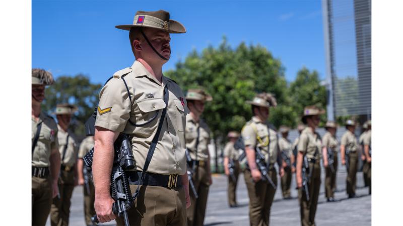 Military personnel stand to attention.