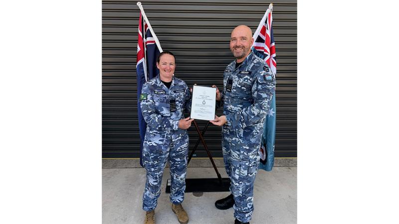 Two military members exchange an award.