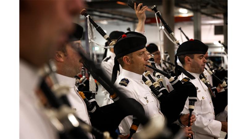 A group of military musicians play the bagpipes.