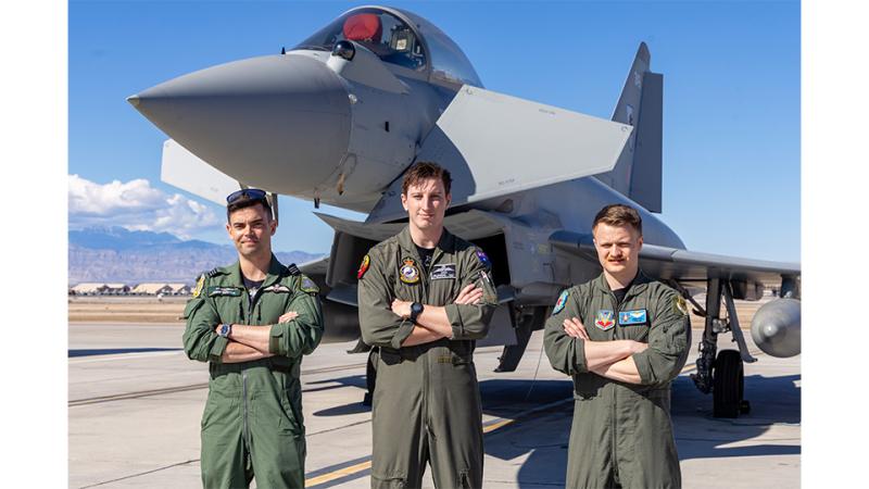 Three military members in front of an aircraft.