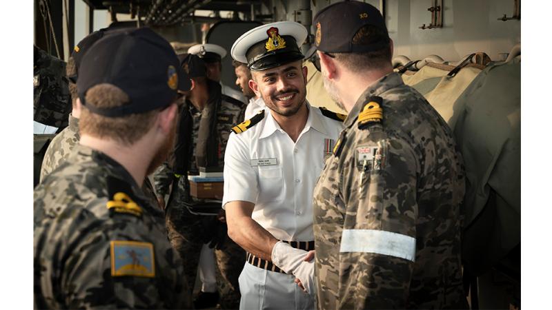 Military members greet each other and shake hands.