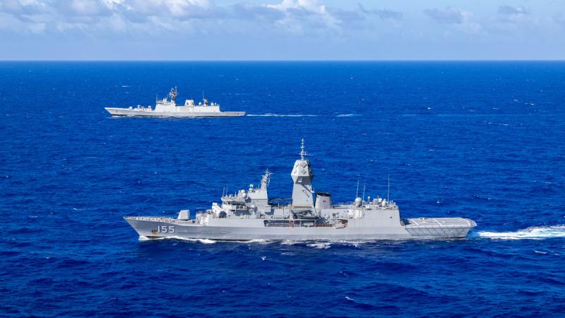 Two ships sailing next to each other in the ocean.