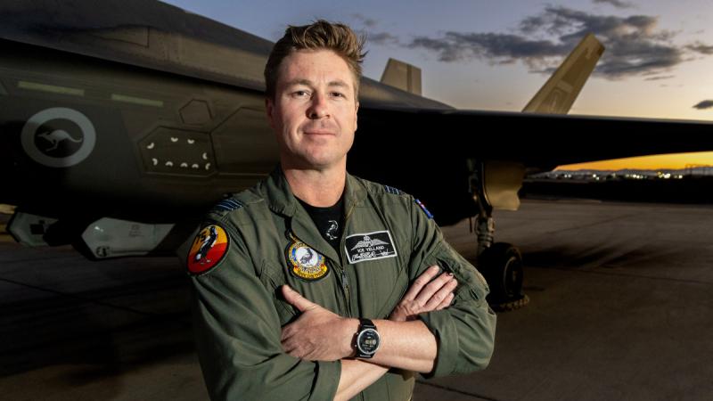 Royal Australian Air Force pilot Squadron Leader Anthony poses in front of an aircraft on the flight line at Nellis Air Force Base, United States, during Exercise Red Flag 26-1.