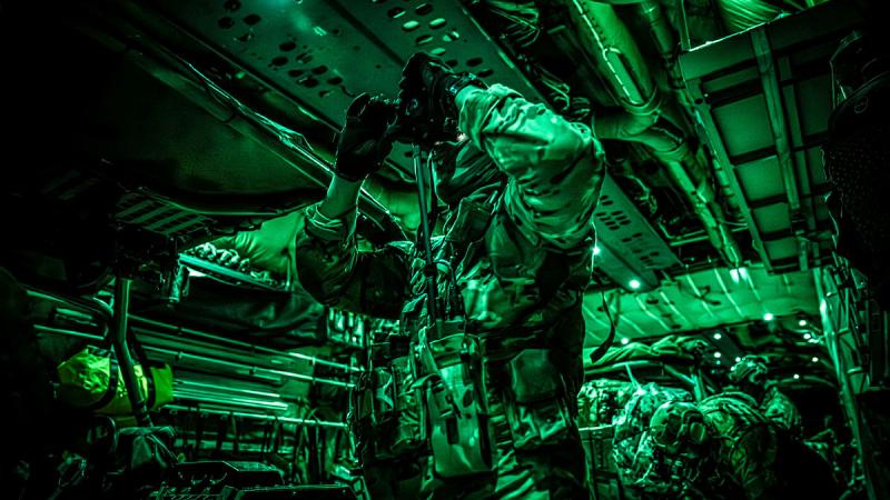 Green light makes a single military member visible inside an aircraft. 