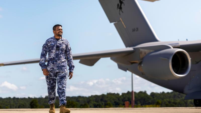 A man in military uniform stands by an aircraft.