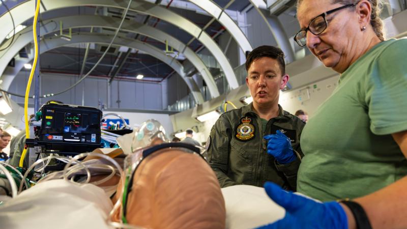 Two Air Force medical personnel examine a dummy patient in a mock medical situation on a Globemaster.