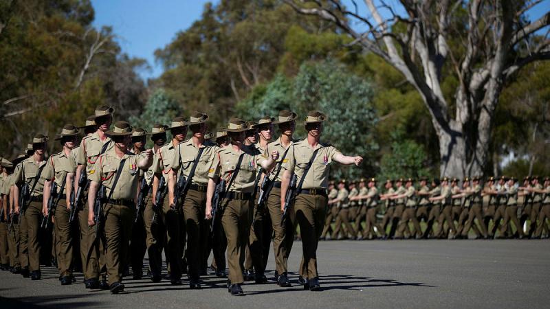 Two groups of Army recruits march in formation in two directions.