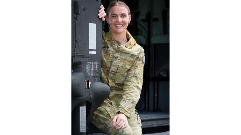 An Army member is seated, wearing her Army uniform.