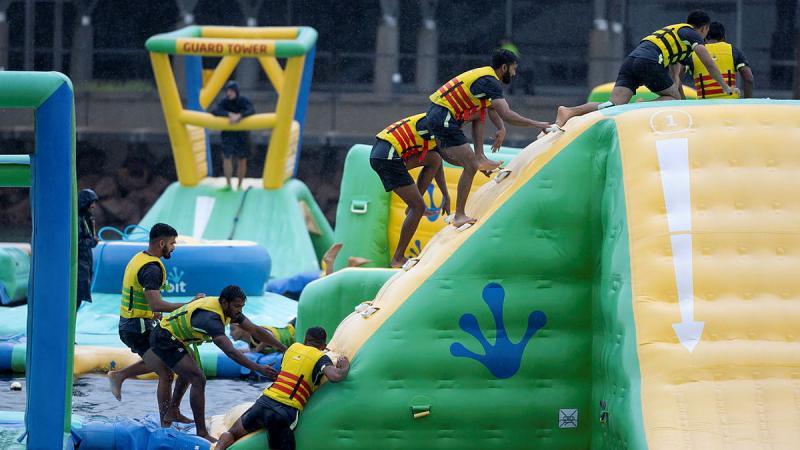 Defence personnel from India climb and inflatable obstacle course.