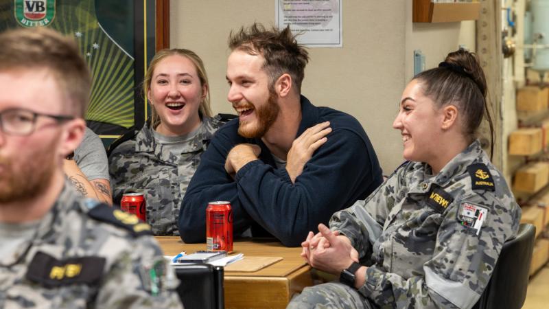 A group of sailors engaging with each other during a quiz night on HMAS Toowoomba.