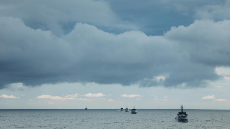 Five patrol boats travel across open water in a loose diagonal formation.