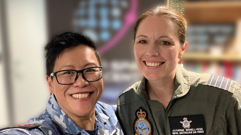 Two women in uniform smiling as they take a selfie from the shoulders up.