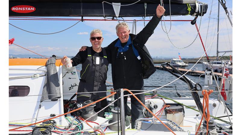 Two men celebrate while aboard a boat.