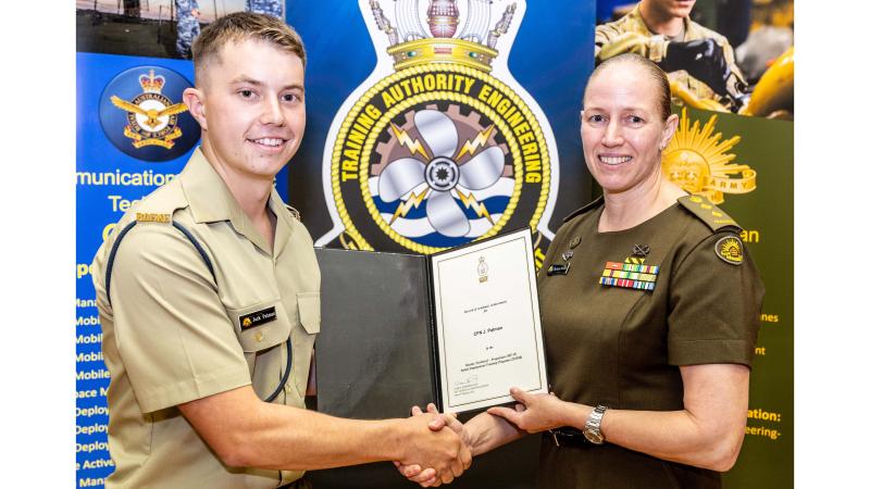 One Army member presents another with a certificate.